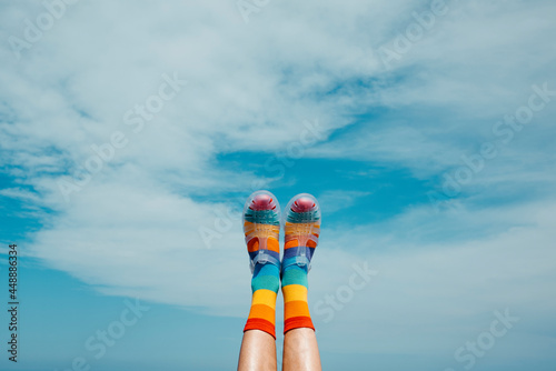 rainbow patterned socks and sandals against the sky photo