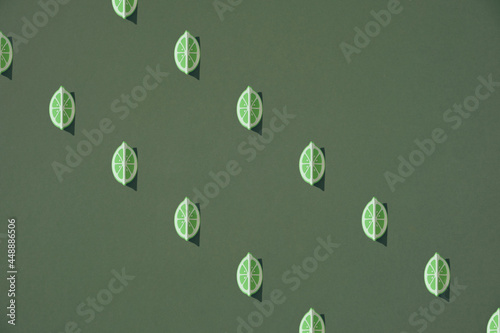 Colorful fruit pattern of lime slices on green background