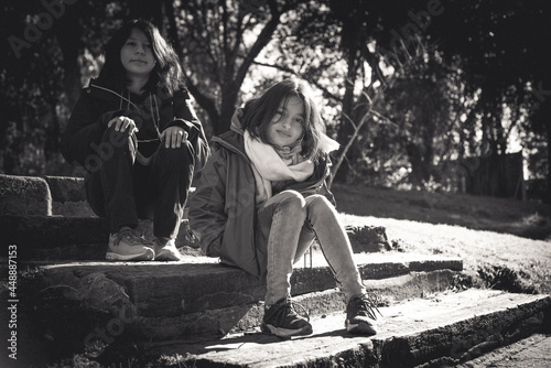 niñas adolescentes sentadas en escalera con escalones de durmientes de quebracho antiguo blanco y negro photo