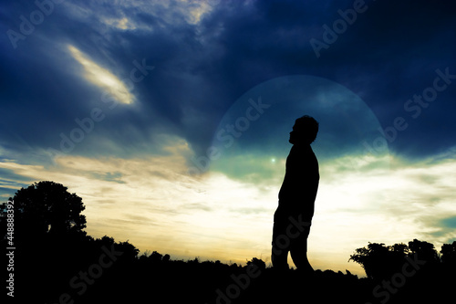 Silhouette of a man standing outdoors in light