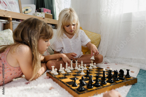 Kids playing chess at home photo