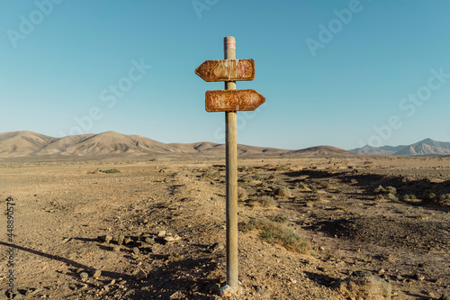 Rusty metal sign in the middle of desertic landcape photo
