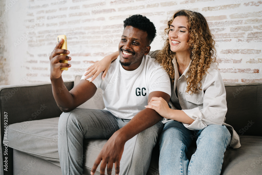 Happy diverse couple using smartphone Happy diverse couple using smartphone