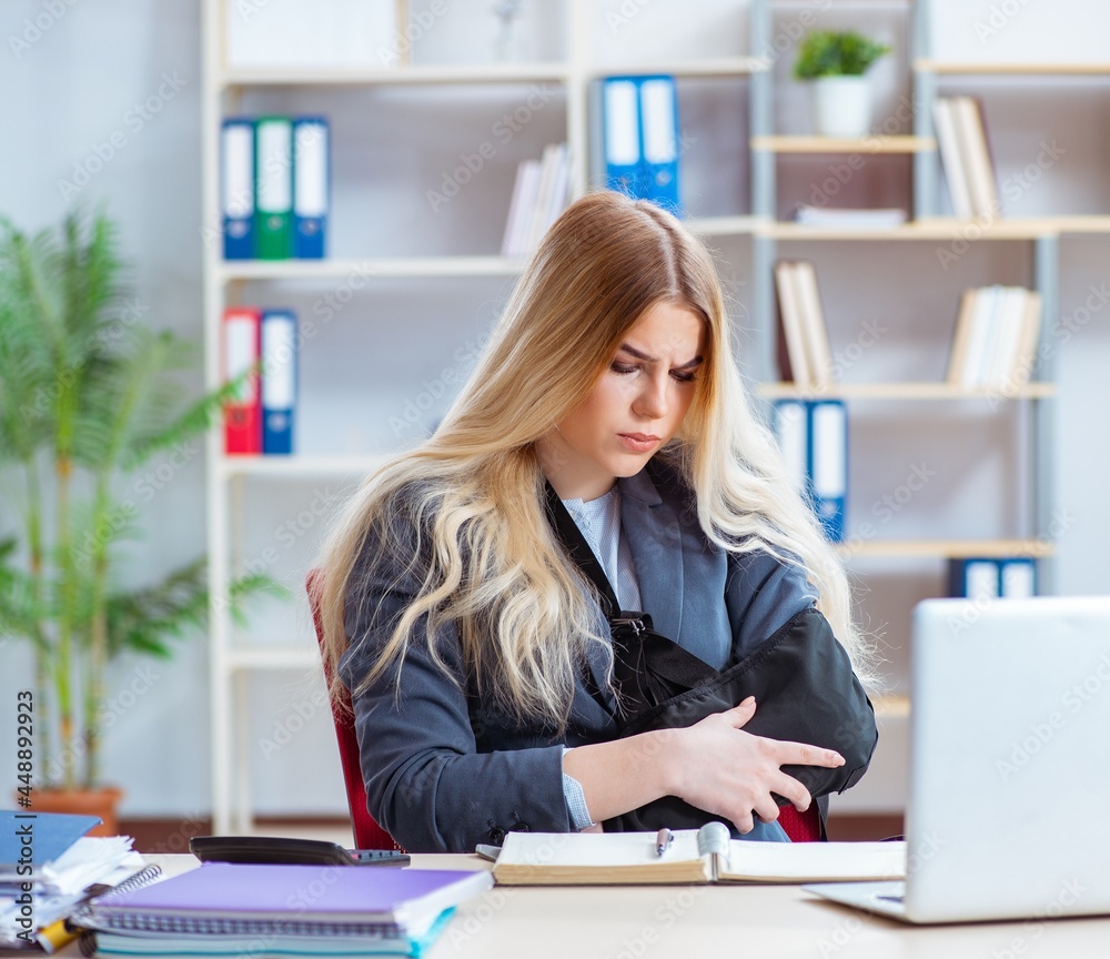 Injured female employee working in the office Injured female employee working in the office