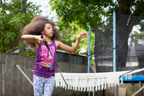 Young girl serving a badminton birdie photo