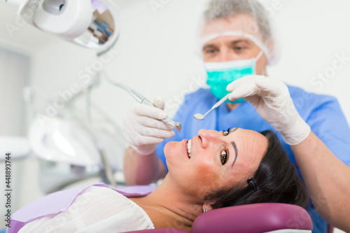 dentist professional filling teeth woman patient sitting in medical chair