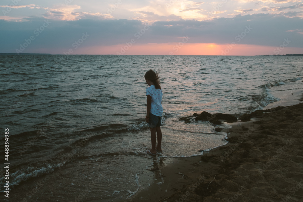 Young girl on beach at sunset Stock Photo | Adobe Stock