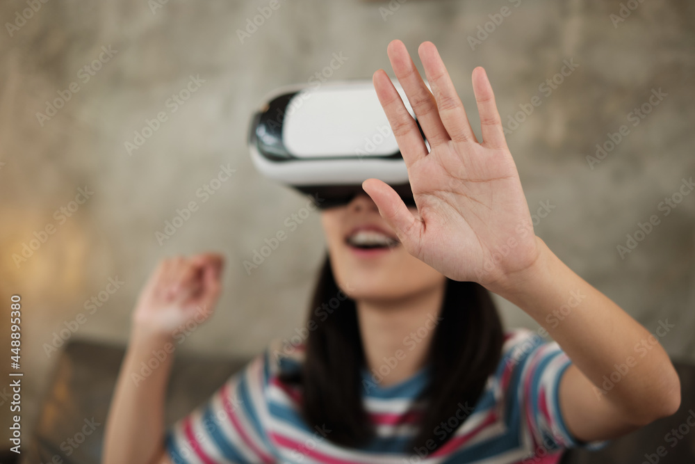 Asian woman with VR glasses headset, watching 3D virtual reality simulation gaming. Interactive entertainment technology gadget is innovative. People enter futuristic cyberspace, modern lifestyle. Asian woman with VR glasses headset, watching 3D virtual reality simulation gaming. Interactive entertainment technology gadget is innovative. People enter futuristic cyberspace, modern lifestyle.