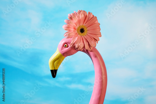 fake pink flamingo in front of the sky photo