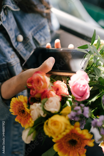 Anonymous Woman on the Bus with Phone and Flowers photo