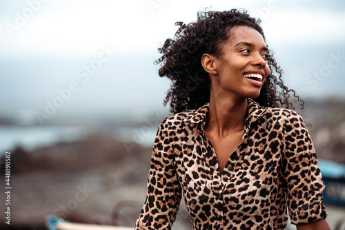 Black woman sitting on boat near seashore with the ocean background photo