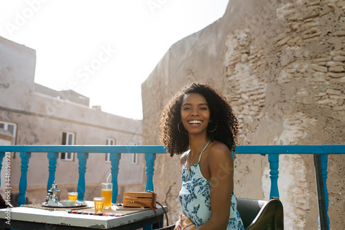 Beautiful black woman sitting in a coffee balcony photo
