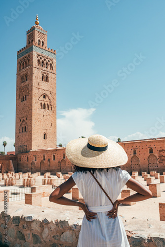 Anonymous African woman looking into a magnificent tower in Marrakesh photo