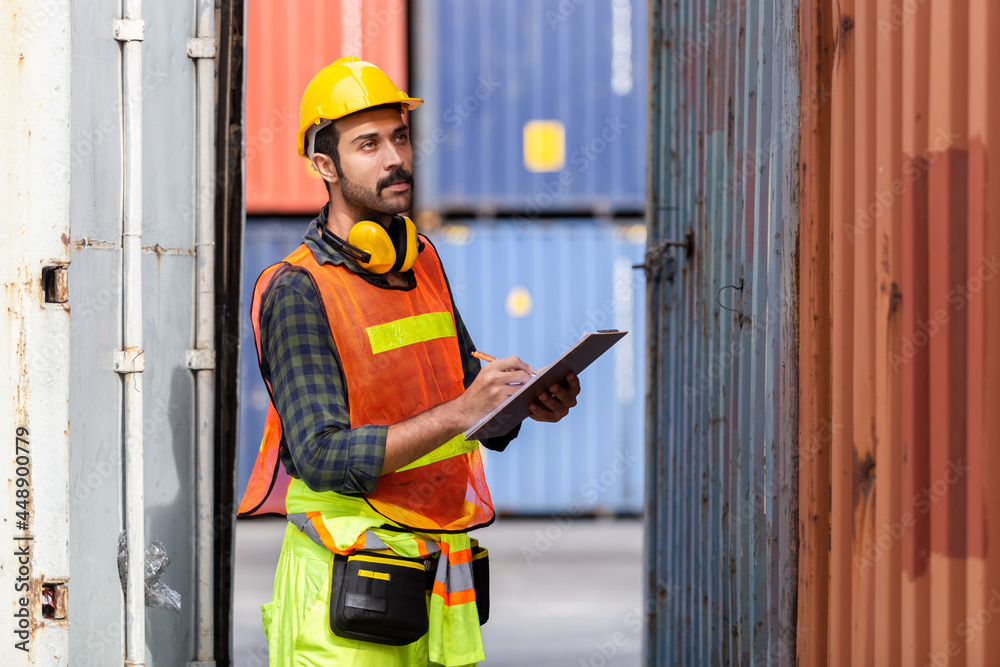 man engineering wear uniform and hardhat holding clipboard checking containers loading. area logistics import export and shipping