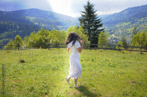 Young woman is walking and jumping on the mountain meadow. Enjoying summertime