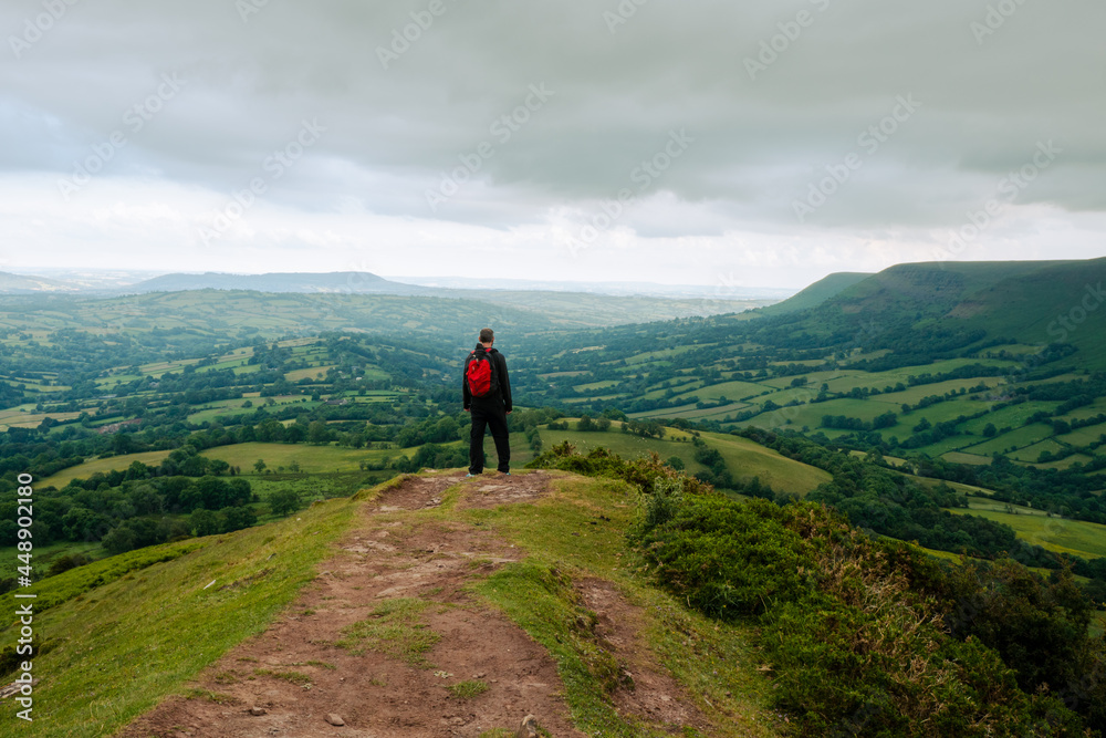 A lone hiker back to camera standing on a hill. A lone hiker back to camera standing on a hill.