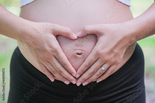 Wallpaper Mural 8 month pregnant woman rubs her stomach in a heart shape Torontodigital.ca