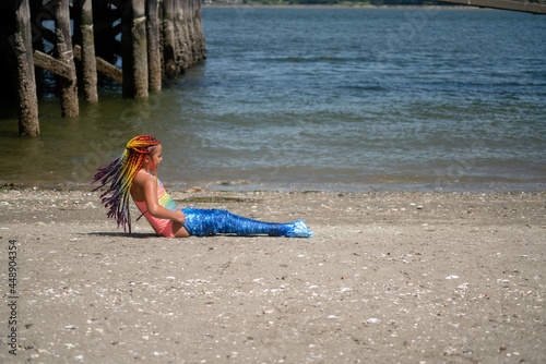 Girl's braids fly as she struggles into mermaid tail 
 photo