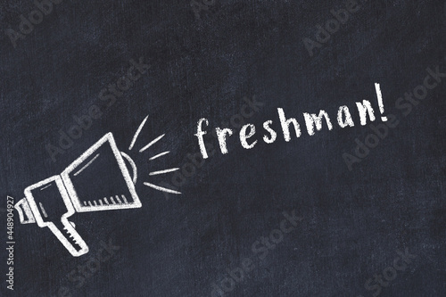 Photography Chalk loudspeaker and inscription freshman on black chalkboard
