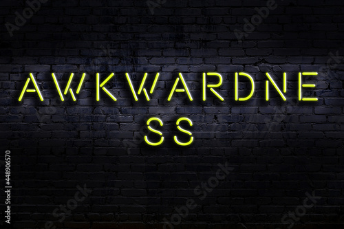 Fotografija Night view of neon sign on brick wall with inscription awkwardness