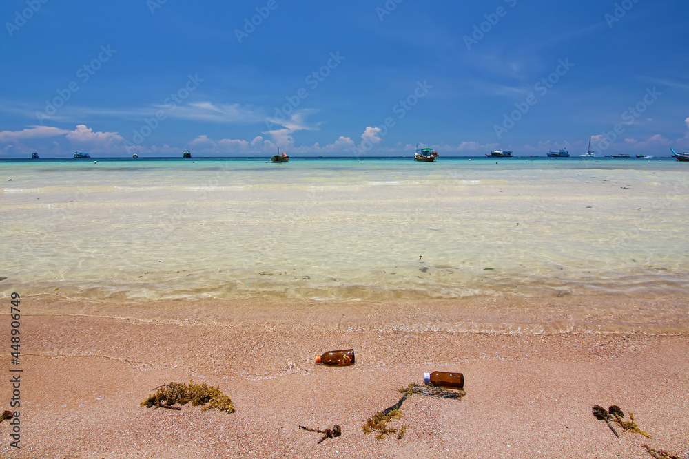 Obraz premium Thailand travel island Koh Tao with bottle garbage on sand beach and turquoise sea water with peace clear blue sky landscape background