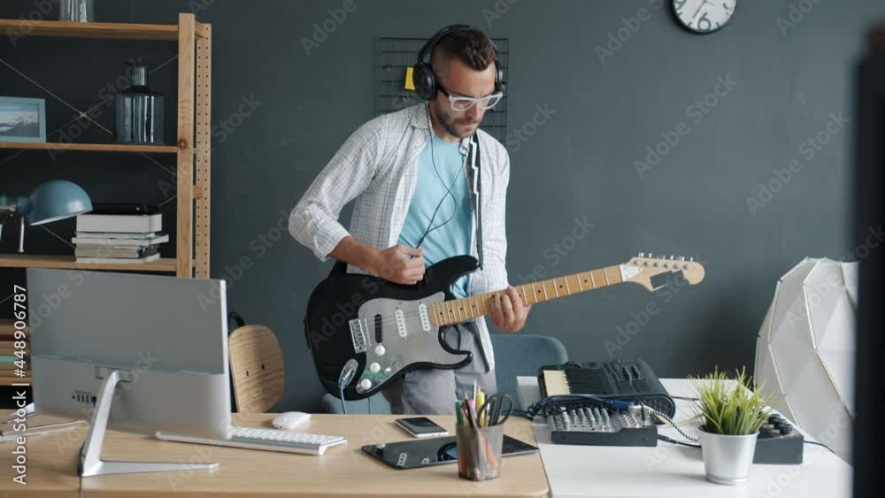 Portrait of young male performer practicing with electric guitar playing at home recording music with modern equipment. Occupation and culture concept.