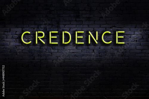 Night view of neon sign on brick wall with inscription credence