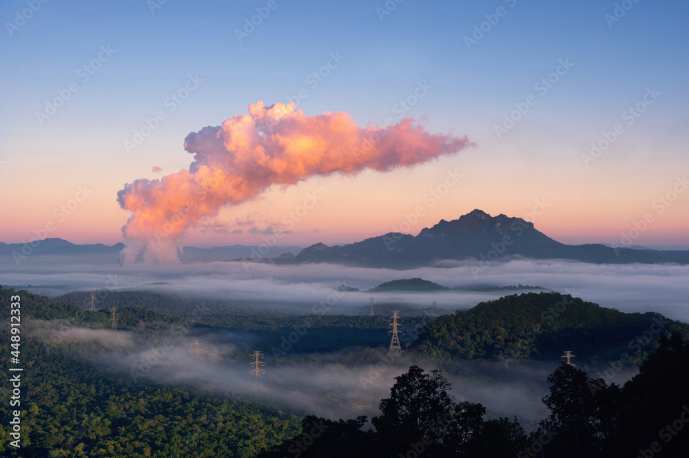Beautiful sea of fog in the mountains, high voltage pole and steam from the coal power plant in the morning sunrise . Mae moh, Lampang, Thailand. Energy and environment concept .
