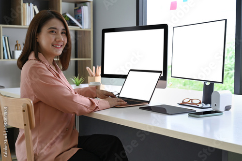 Smiling businesswoman working with modern gadget at office.