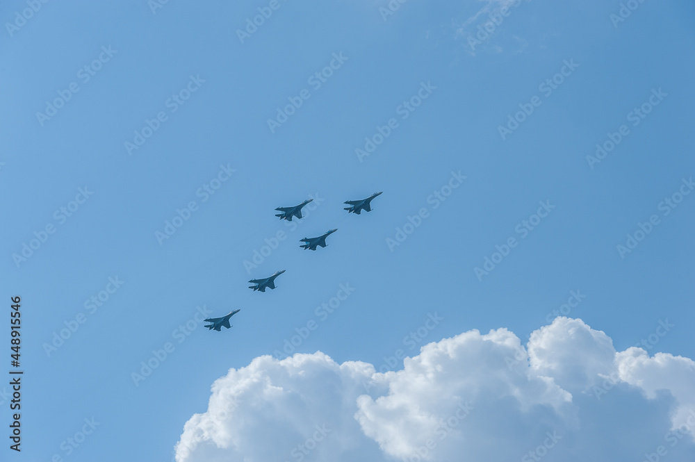 Military planes are flying in the blue sky above white clouds Military planes are flying in the blue sky above white clouds