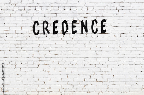 White wall with black paint inscription credence on it