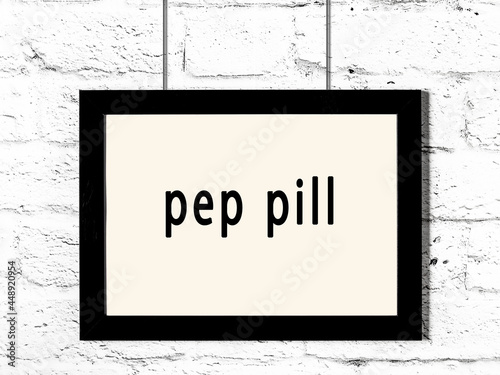 Black frame hanging on white brick wall with inscription pep pill photo