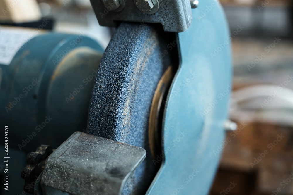 Detail of a grinding machine for sharpening carving knives and smoothing metal in the workshop of a craftsman or craftswoman, copy space, selected focus