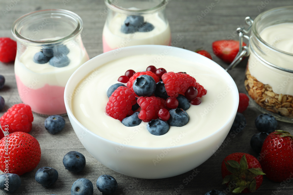 Concept of tasty breakfast with yogurt on gray textured table Concept of tasty breakfast with yogurt on gray textured table