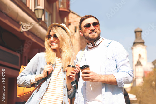 Happy couple with coffee on city street in morning