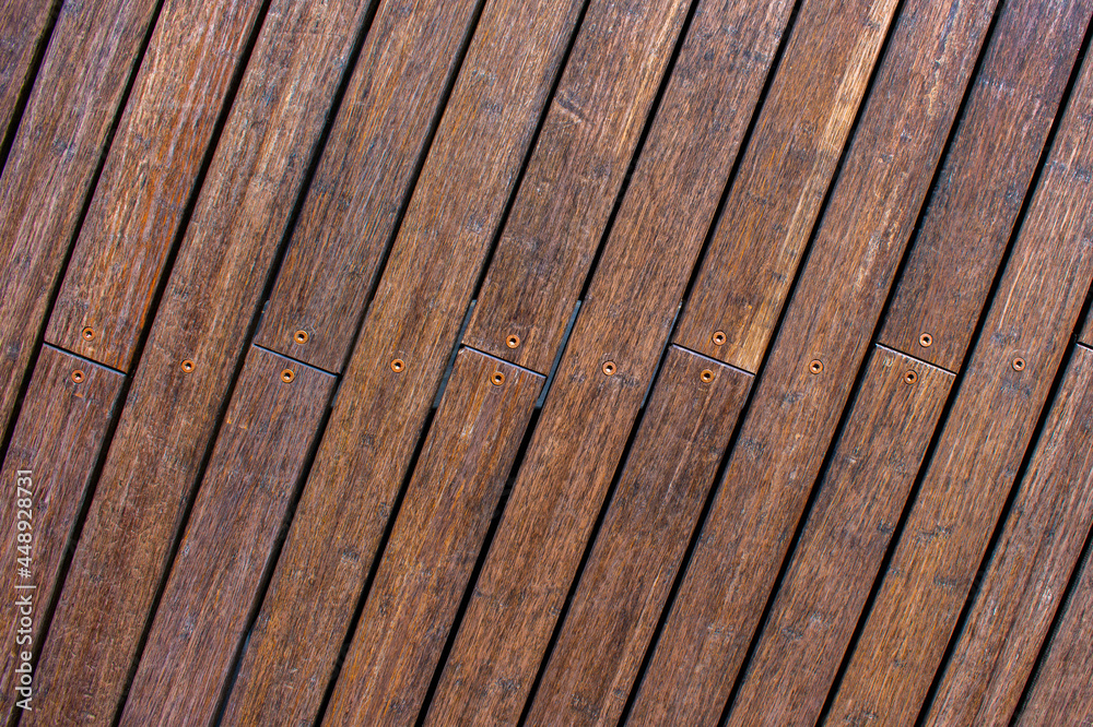 Background from dark wooden planks with metal nails. The boards are inclined. Background from dark wooden planks with metal nails. The boards are inclined.
