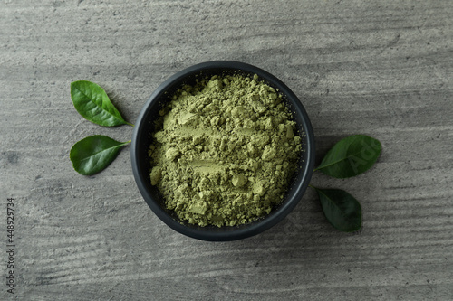 Plate of matcha powder on gray textured background