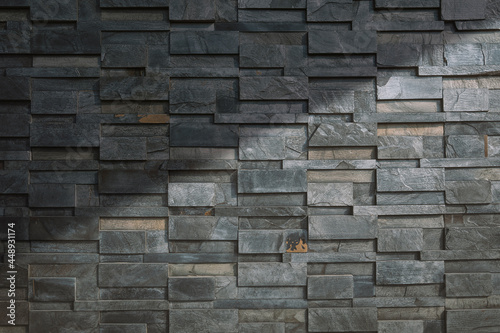 Sunlight and shadow on surface of  gray stone slate wall background in vintage tone style