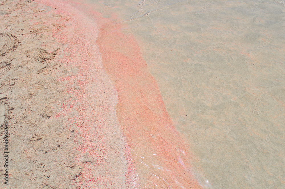 A strip of pink sand on the seashore in Greece.