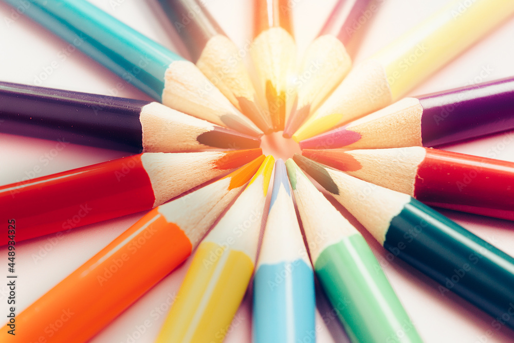 A figure of colored pencils in the shape of the sun with rays. The concept of creativity or development of the group. Abstract background. minimalism. A figure of colored pencils in the shape of the sun with rays. The concept of creativity or development of the group. Abstract background. minimalism.