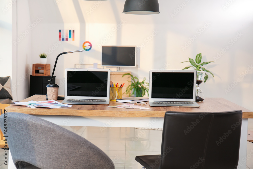 Stylish workplace of graphic designers with laptops in office Stylish workplace of graphic designers with laptops in office