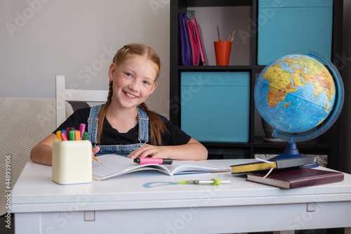  cute happy caucasian redhead girl studying at home photo