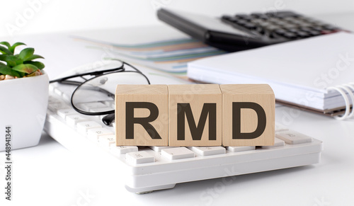 RMD required minimum distributions written on a wooden cube on keyboard with office tools photo