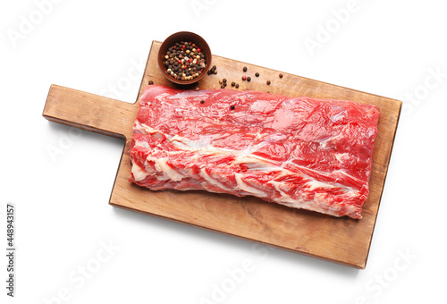 Wooden board with raw beef brisket and spices on white background photo