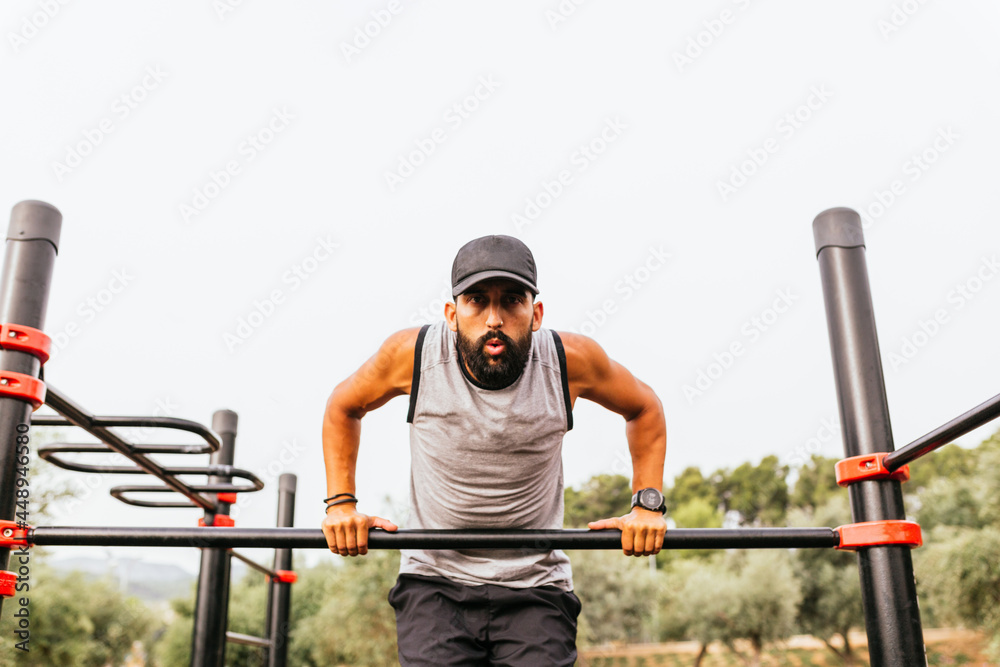 Boy doing sport outdoors on bars Boy doing sport outdoors on bars