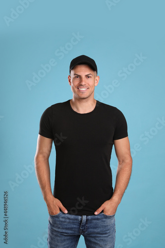 Happy man in black cap and tshirt on light blue background. Mockup for design