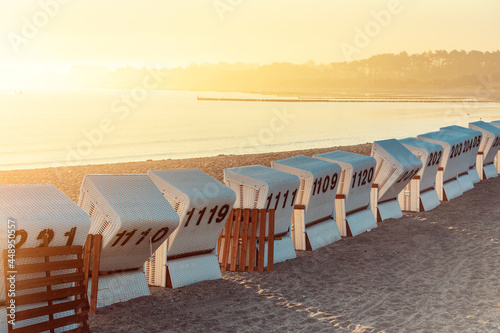 Fototapeta Naklejka Na Ścianę i Meble -  backs of Baltic Sea beach chairs with numbers in the morning sunlight 