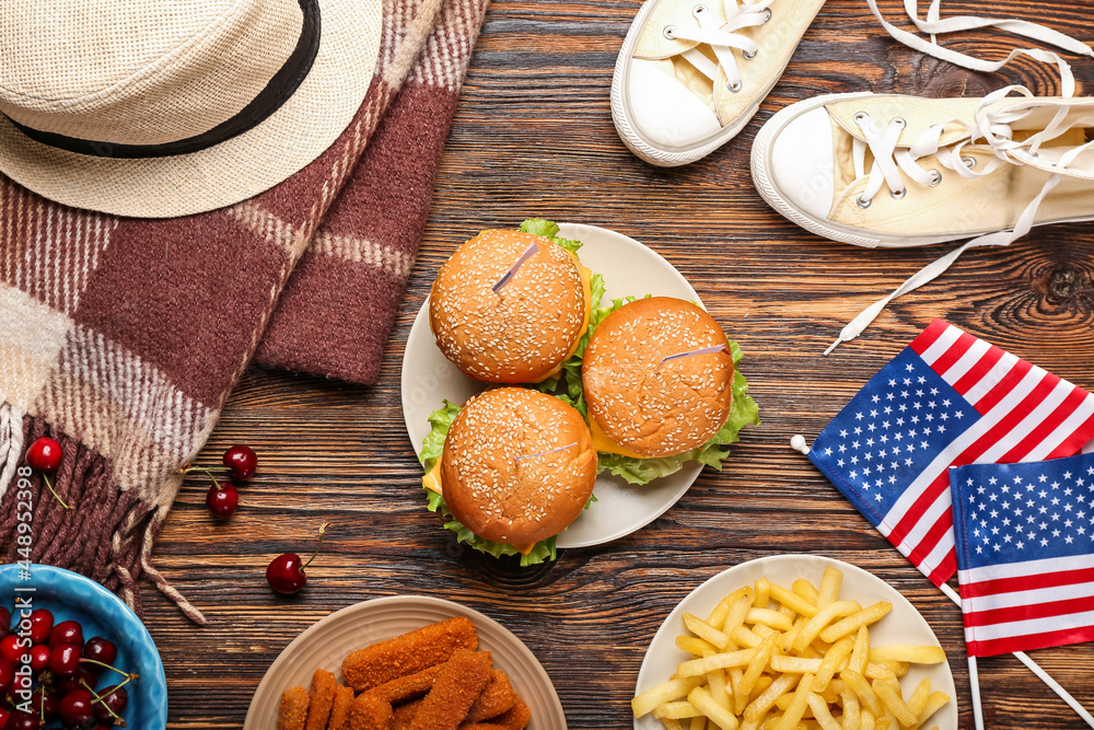 American flags with traditional food, clothes and plaid on wooden background