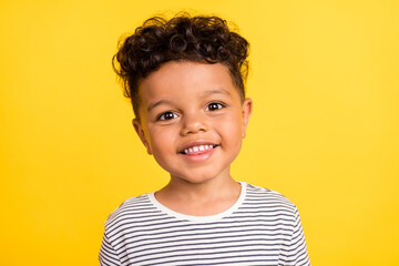 Photo portrait cheerful small boy smiling in striped shirt isolated bright yellow color background