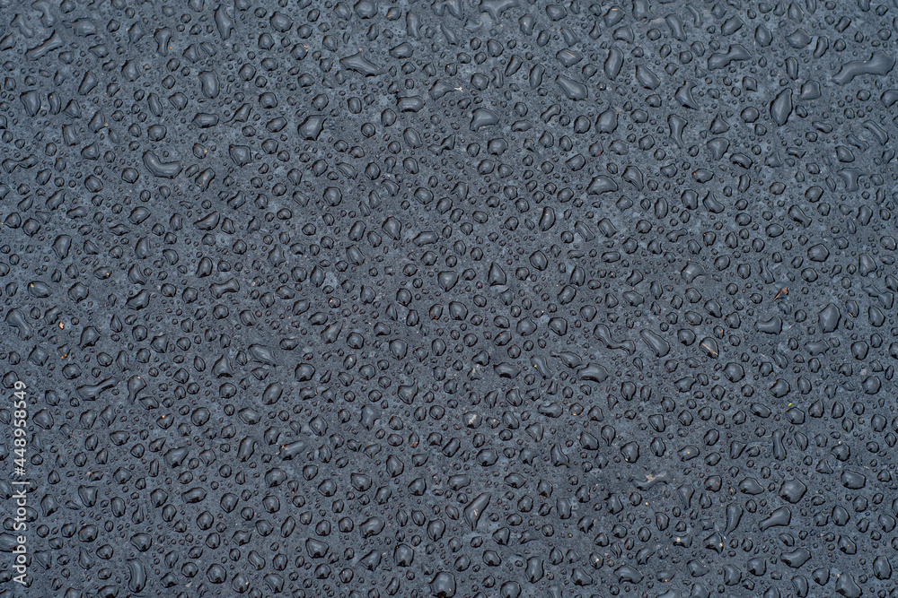 Dark background with large drops of water on fresh asphalt. Road surface wet from rain. Black sad backdrop Dark background with large drops of water on fresh asphalt. Road surface wet from rain. Black sad backdrop
